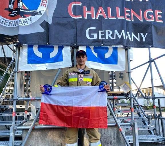Zwycięzca Firefighter Combat Challenge Germany 2021 mł. kpt. Rafał Bereza z Flagą Polski