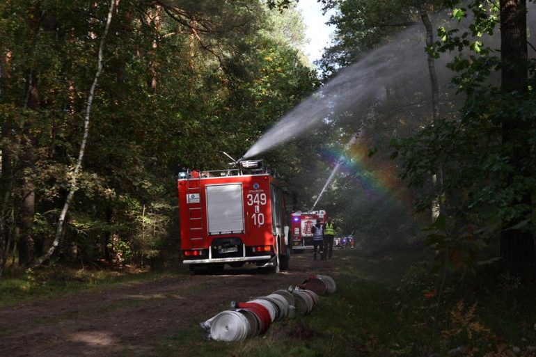Pojazdy gaśniczy podają wodę z działek na samochodach